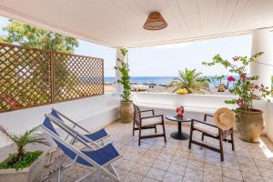 a patio with chairs and a table and a view of the ocean at Hotel Ossidiana Stromboli Center in Stromboli