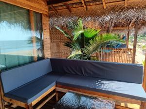 a blue bench in a room with a palm tree at Bamboo Yoga Retreat in Canacona