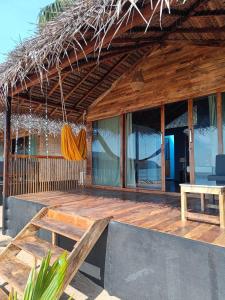 a wooden deck with a bench and a hut at Bamboo Yoga Retreat in Canacona