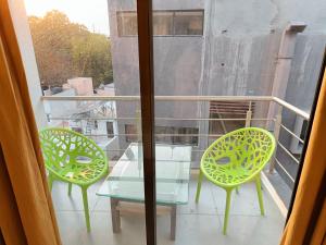 two chairs and a glass table on a balcony at Hotel Lotus in Anand