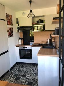 una cocina con armarios blancos y fregadero en Le Birdie - 3 bedroom apartment at the Golf de Giez and 5 minutes from the, en Giez