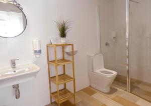 a bathroom with a sink and a toilet and a mirror at ISA Sevilla Suites in Seville