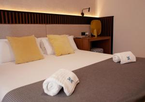 a hotel room with a bed with towels on it at ISA Sevilla Suites in Seville