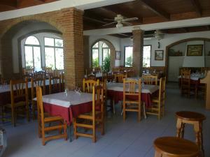 una sala da pranzo con tavoli, sedie e finestre di Pensión Restaurante Venta El Molino a Sopalmo