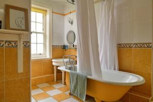 a bathroom with a tub and a sink at Finest Retreats - Edwardian Country House - 9 Bed, Sleeping up to 21 in Longtown +53 photos
