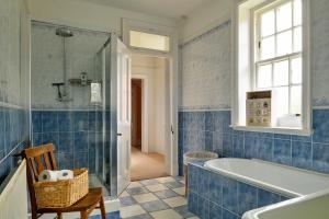 baño de azulejos azules con bañera y lavamanos en Finest Retreats - Edwardian Country House - 9 Bed, Sleeping up to 21 en Longtown