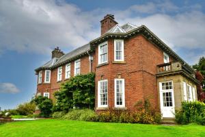 Finest Retreats - Edwardian Country House - 9 Bed, Sleeping up to 21 في Longtown: مبنى من الطوب الأحمر كبير مع نوافذ بيضاء