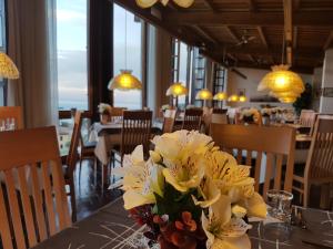 un jarrón de flores sobre una mesa en un restaurante en Hotel Palazzina, en Gargnano