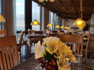 a vase of flowers on a table in a restaurant at Hotel Palazzina in Gargnano