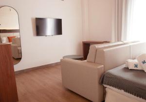 ISA Sevilla Suites في إشبيلية: غرفة معيشة مع كرسي ومرآة