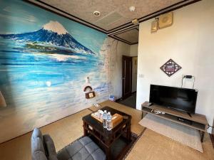 a living room with a large painting on the wall at Ming Ren Hotspring Hotel in Jiaoxi