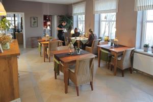a restaurant with wooden tables and chairs and people eating at Hotel Alte Landschule in Langballig