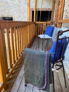 una terraza con 2 sillas y una manta. en Dependance GRIMANI, en Ampezzo