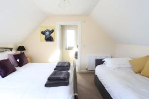 a bedroom with two beds and a window at THE DEN, a Secluded Annex, Hot-tub, Heating & Breakfast in Long Bredy