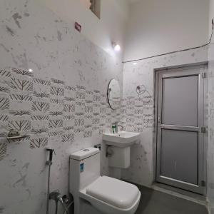 a bathroom with a toilet and a sink at KRAZYROOMS, Kaziranga in Kāziranga