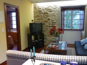 - un salon avec un canapé et une télévision dans l'établissement Apartamento Tránsito de Entrerruas, à Saint-Jacques-de-Compostelle