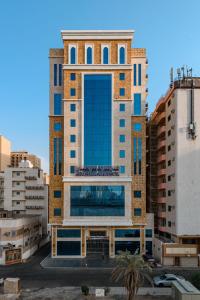 a tall building with blue windows in a city at Abdul Hafez Al Humaidan Hotel in Makkah