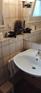 a bathroom with a white sink and a window at Hotel am Theater in Schwetzingen