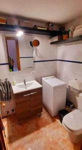 a bathroom with a white toilet and a sink at Casa Pereza in Trevélez