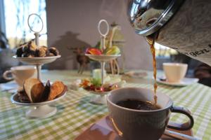 a person is pouring coffee into a cup on a table at Hotel Alte Landschule in Langballig