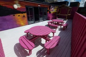 a group of picnic tables and chairs on a deck at Penthouse Apartment, Sleeps 21 with terrace in Liverpool
