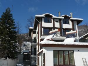 a building with snow covered chairs on the roof at House Arirang in Cherni Osŭm