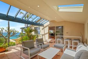 a living room with chairs and a view of the ocean at Spacious Home with Ocean Views, Close to Beach in Wamberal