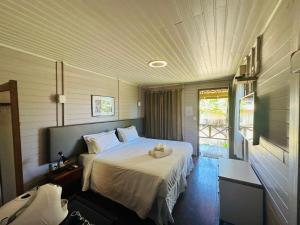 Un dormitorio con una cama con un edredón blanco. en Pousada Simpatia da Ilha, en Fernando de Noronha