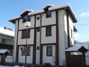 a white building with snow on top of it at House Arirang in Cherni Osŭm
