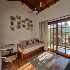 1 dormitorio con cama, mesa y ventana en Pousada da Mata, en Cunha
