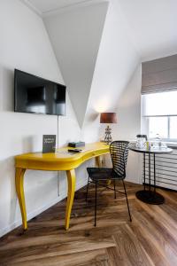 a yellow desk with a chair in a room at Broeck Oudewater in Oudewater