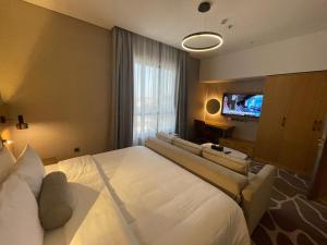 um quarto de hotel com uma cama grande e uma televisão de ecrã plano em BN Residence em Al Khobar