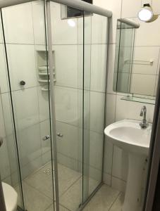 een badkamer met een glazen douche en een wastafel bij Casa de Praia - tipo chalé in Barra de Santo Antônio