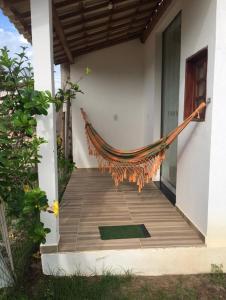 a hammock hanging from the side of a house at Casa de Praia - tipo chalé in Barra de Santo Antônio