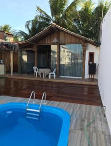 a house with a swimming pool in front of a house at Casa de Praia - tipo chalé in Barra de Santo Antônio