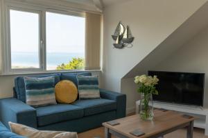 a living room with a blue couch and a tv at Higher Upover in Woolacombe