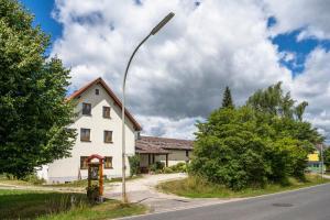 a street light in front of a white house at Ferienwohnung Haus Inge in Moosbach