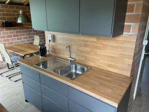 uma cozinha com um lavatório e uma bancada de madeira em Rekerlanden 98 em Schoorldam