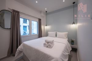 a bedroom with a white bed with two towels on it at Yellow Door, Nilie Hospitality MGMT in Thessaloniki
