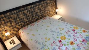 um quarto com uma cama com colcha floral em Casa de temporada Guarapari Casa Dule em Guarapari