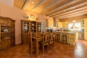 une grande cuisine avec une table et des chaises en bois dans l'établissement Villa Estrellita Sant Lluis, à Sant Lluis