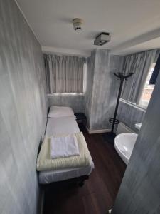 een kleine kamer met een bed en een wastafel bij Amigo Hotel in Amsterdam