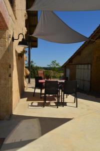 a table and chairs sitting under a white umbrella at Lacassagne in Loubersan
