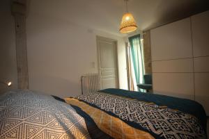 ein Schlafzimmer mit einem Bett mit einer Decke darauf in der Unterkunft Lacassagne in Loubersan
