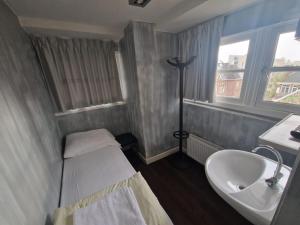 a small room with a sink and a bed and a window at Amigo Hotel in Amsterdam