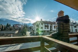 una persona parada en un balcón con vistas a las montañas en Banderitsa Apartments with kitchen & BBQ, en Bansko