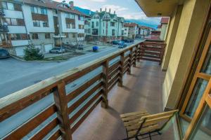 a balcony with a bench and a view of a street at Banderitsa Apartments with kitchen in Bansko +43 photos
