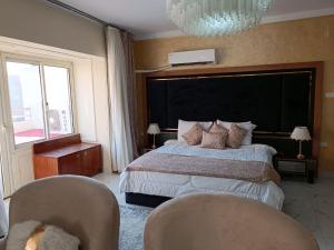 a bedroom with a large bed and two chairs at Indiana Hotel in Cairo