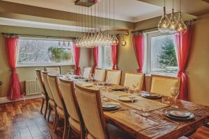 a dining room with a long table and chairs at Loch Ness Mansion in Invermoriston