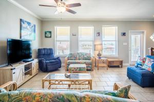 a living room with blue couches and a tv at 3 Sheets To the Zin in Port Aransas